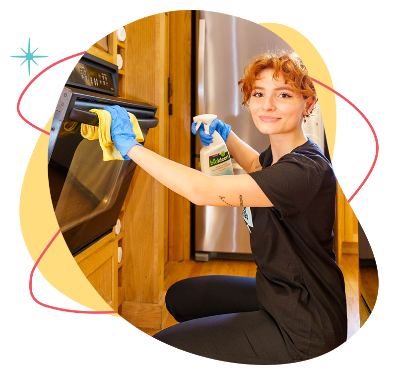 Belle Home cleaner wiping down an oven door